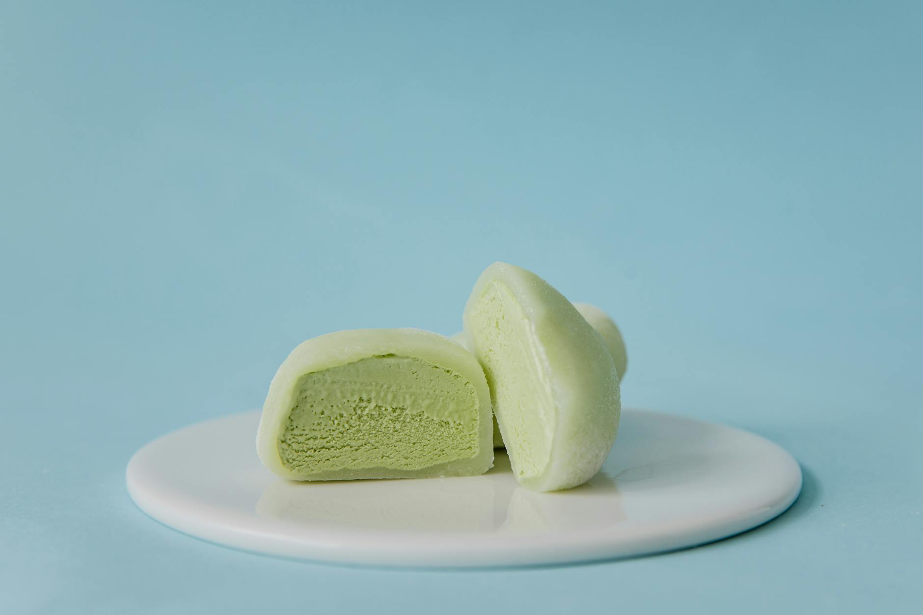 sliced green mochi ice cream on white ceramic plate