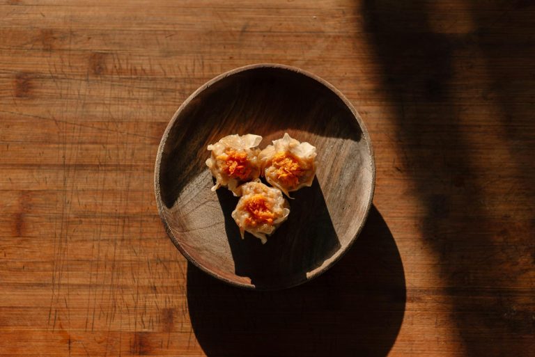delicious dim sum dumplings in wooden bowl